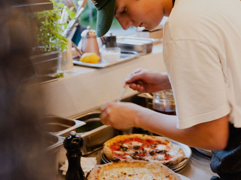 Mitarbeiter backt Pizzen im blyb. Hotel