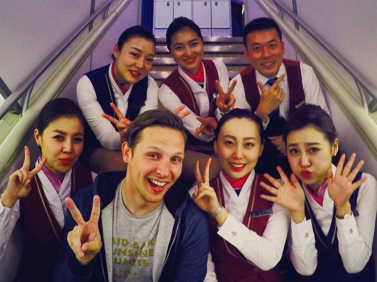 Josh Cahill mit Stewardessen im Flugzeug