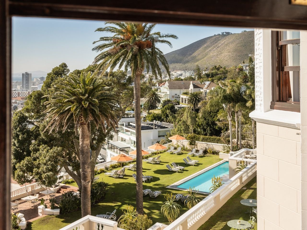 Blick aus dem Fenster auf den begrünten Poolbereich des Hotels