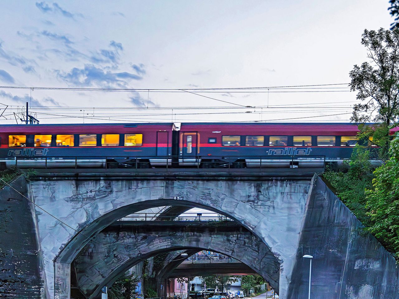 roter Nightjet passiert Brücke in Stuttgart