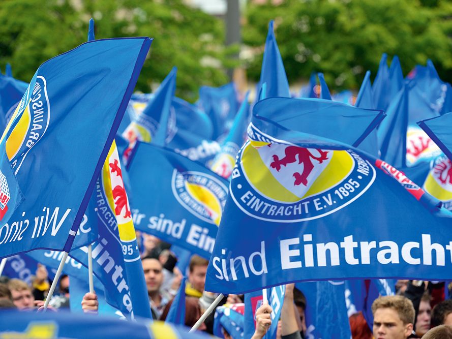 Fans schwenken die blauen Fahnen der Eintracht Braunschweig