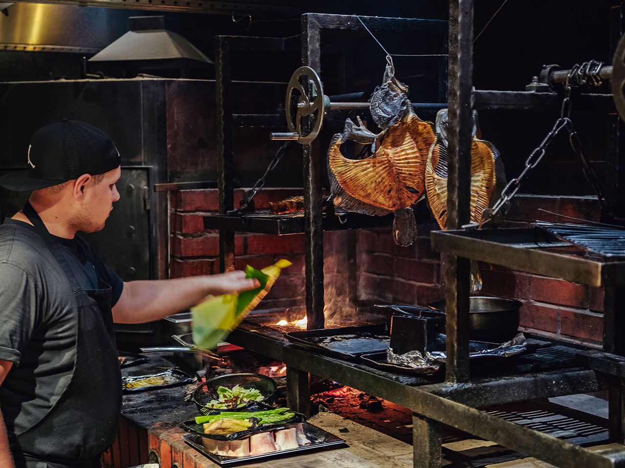 Ein Koch steht am Grill des „11 Woodfire“-Restaurants.