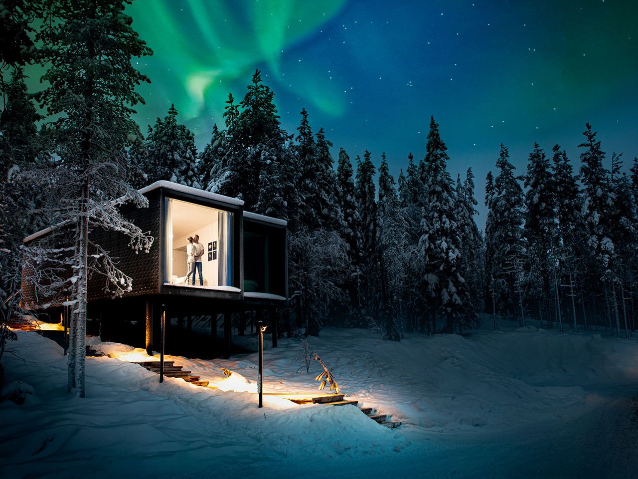 Arctic Treehouse Hotel in Rovaniemi, Paar steht an der Fensterscheibe