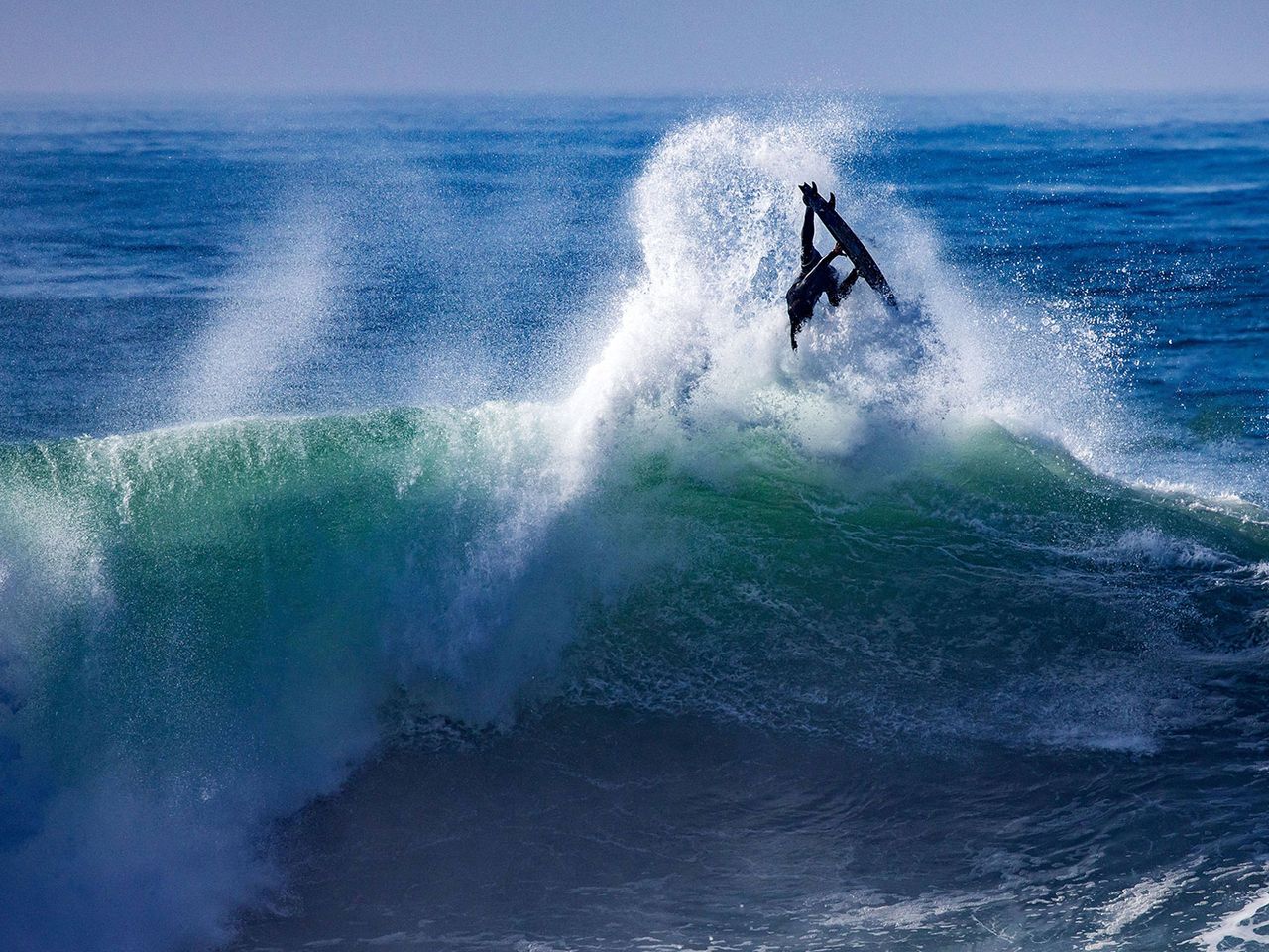 Surfer reitet eine Welle in Nazaré
