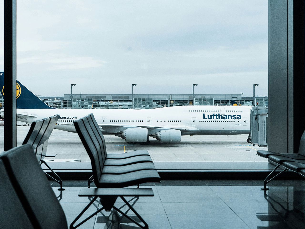 Lufthansa-Flugzeug steht auf dem Rollfeld, zu sehen durch den Wartebereich