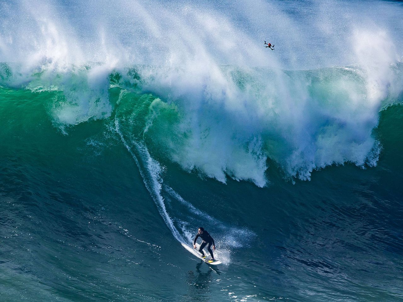 Surfer reitet eine Welle, Nazaré
