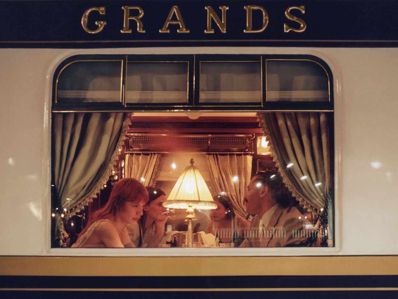 Personen sitzen im Venice Simplon-Orient-Express, Blick durchs Fenster