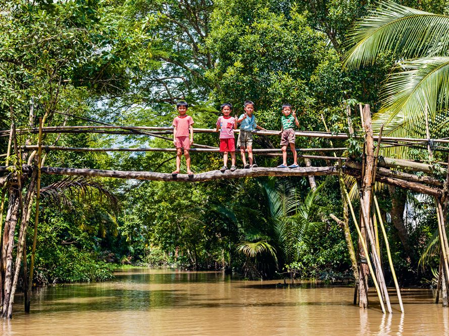 Kinder stehen auf einer Brücke im Mekongdelta, Vietnam