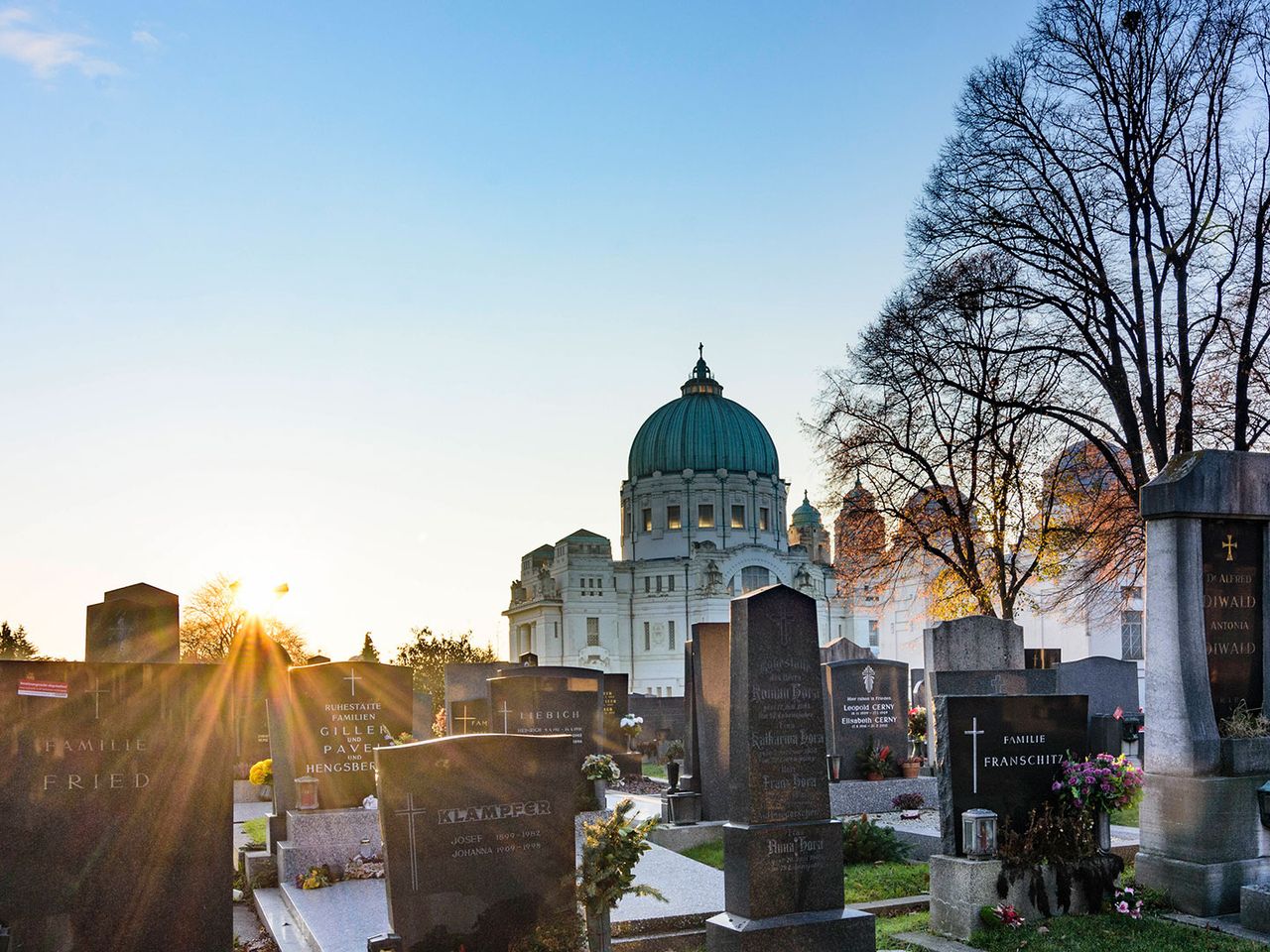Gräber auf dem Friedhof Wien, im Hintergrund die Friedhofskirche zum Heiligen Karl Borromäus