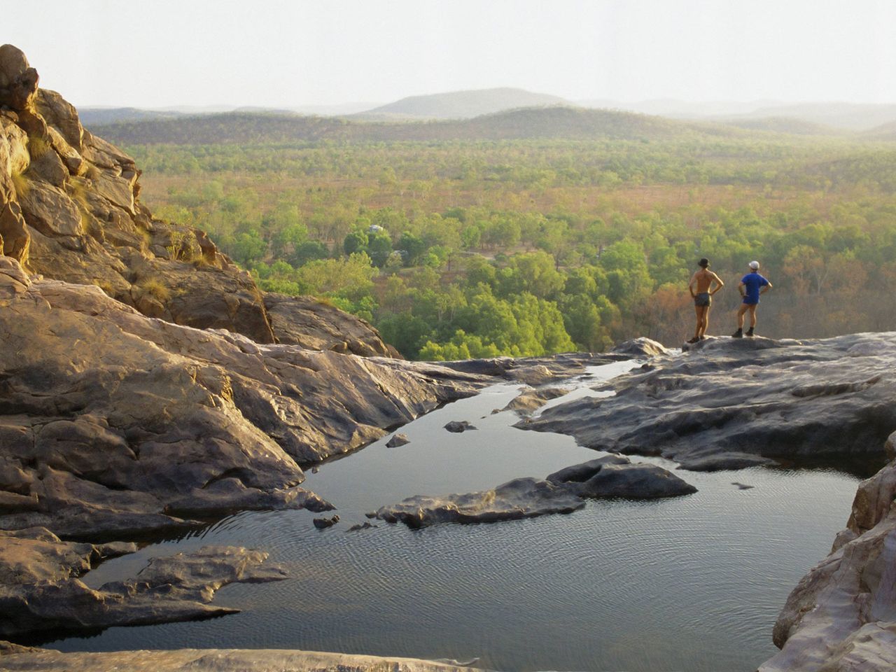 Personen stehen an den Gunlom Falls im Kakadu Nationalpark