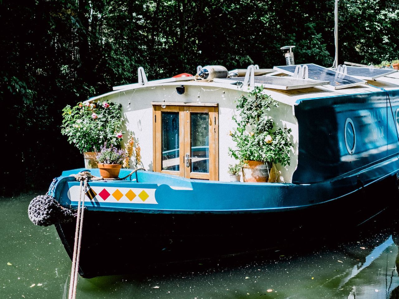 Ein blaues Hausboot liegt im Regent's Canal, London