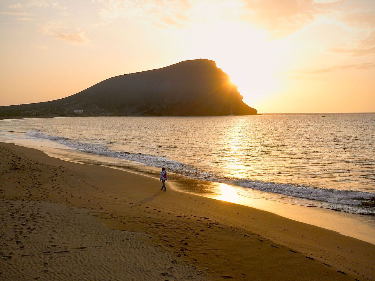 Person spaziert an der Playa de la Tejita, Blick auf Montaña Roja