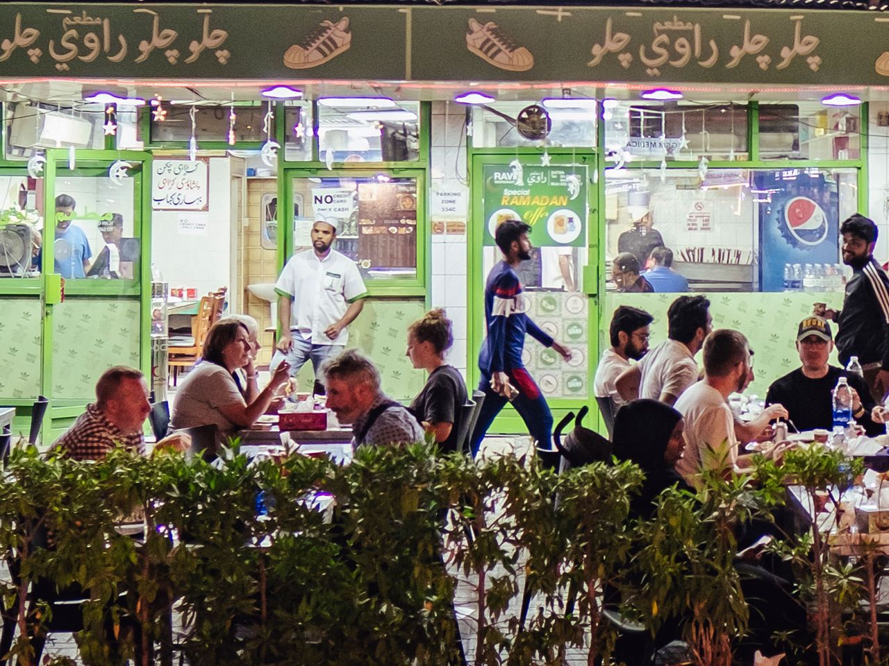 Viele Menschen sitzen vor dem hippen Lokal „Ravi“