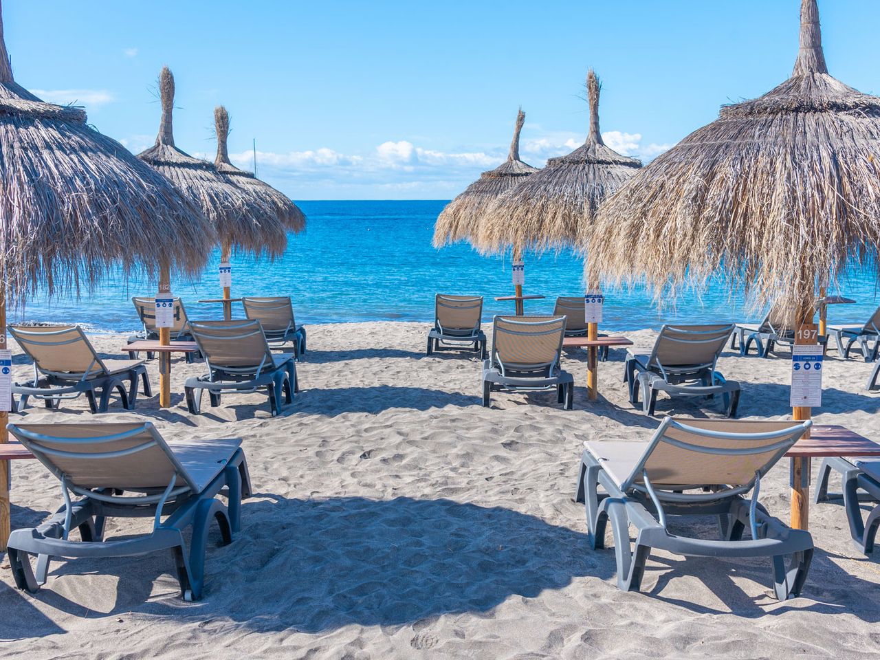 Sonnenliegen und -schirmen an der Playa de Fañabé, Teneriffa