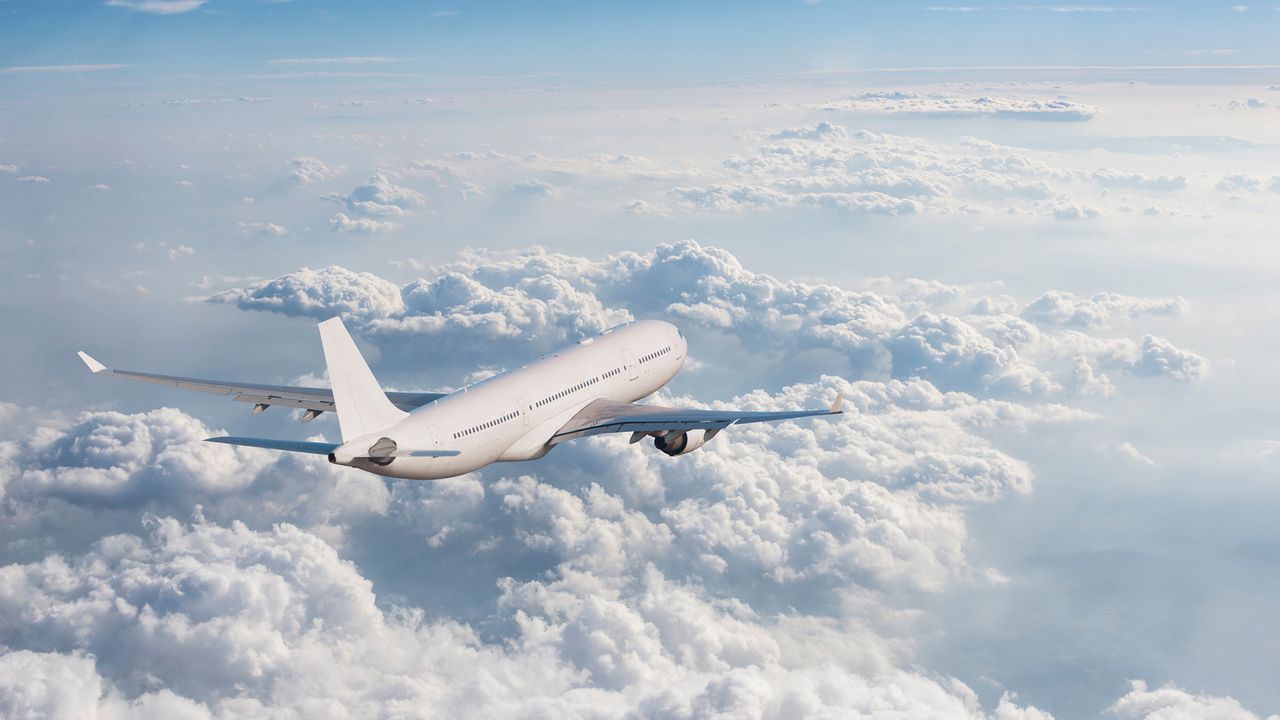 Ein Flugzeug fliegt über den Wolken