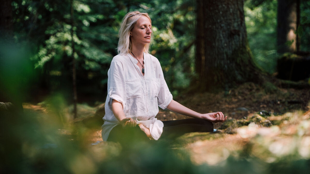 Frau meditiert im Wald