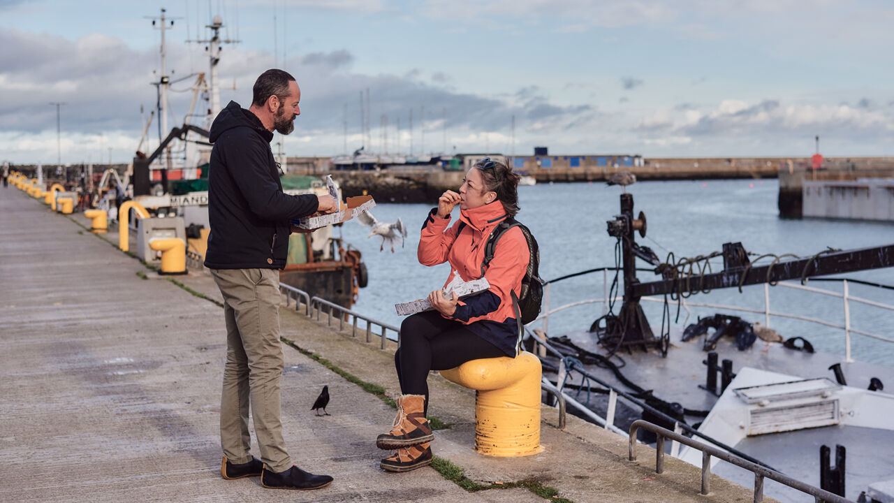 Menschen essen Fish & Chips am Howth Pier