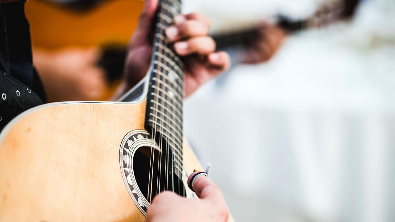 Ein Fado-Musiker spielt auf seiner Gitarre. 