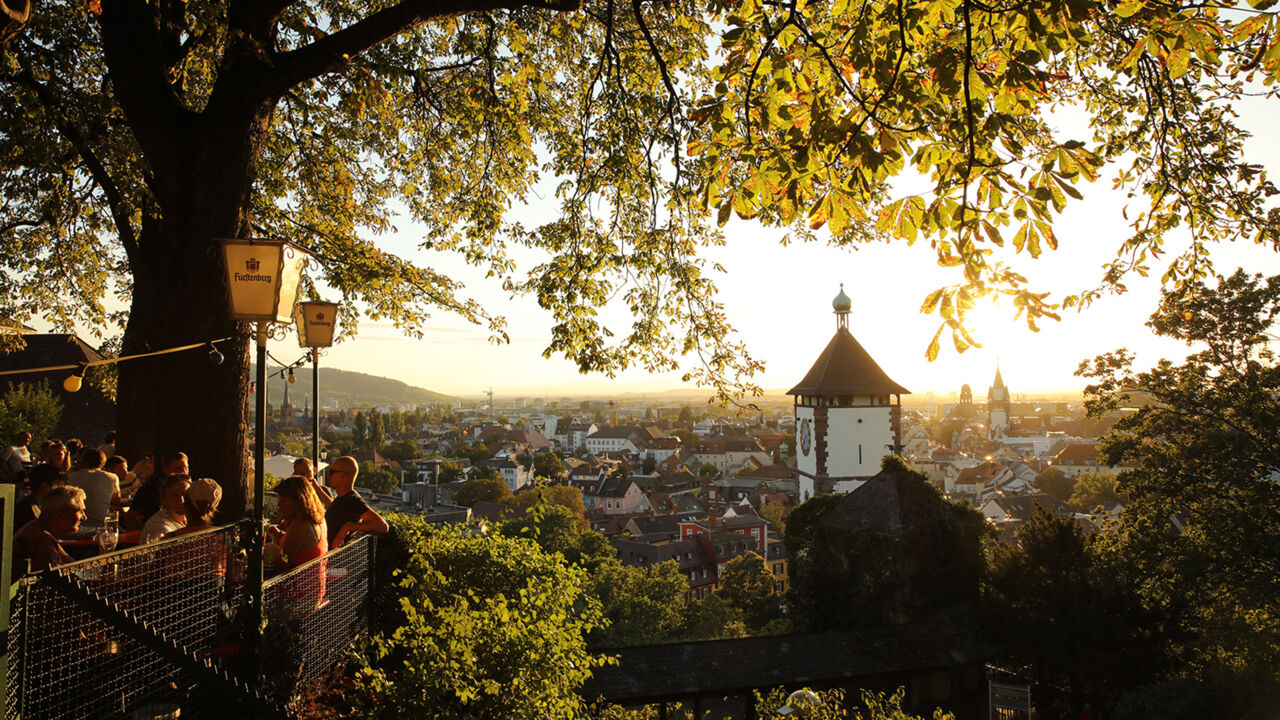 Blick auf die Dächer Freiburgs aus einem Biergarten.