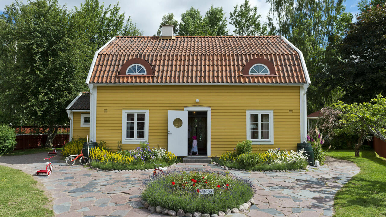Ein gelbes Holzhaus im Freizeitpark „Astrid Lindgrens Welt“