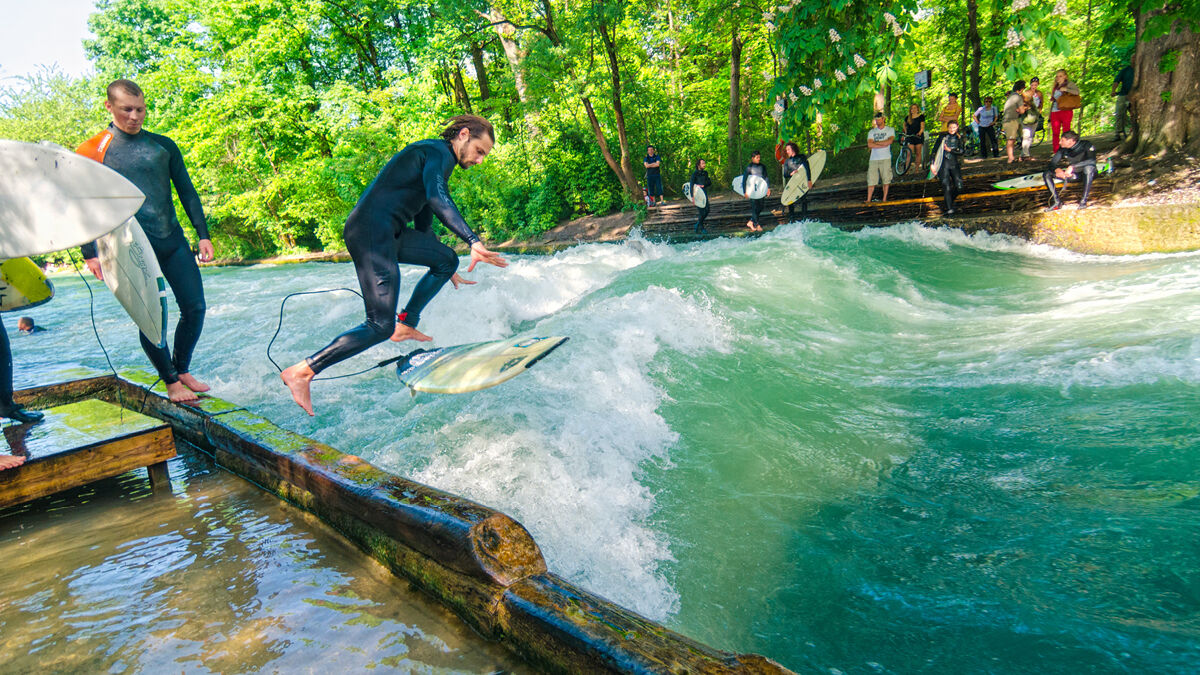 Surfer reiten auf der Eisbachwelle im Englischen Garten