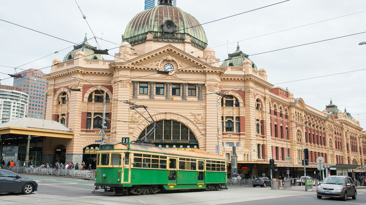 Eine Tram fährt vorbei an den Sehenswürdigkeiten von Melbourne.