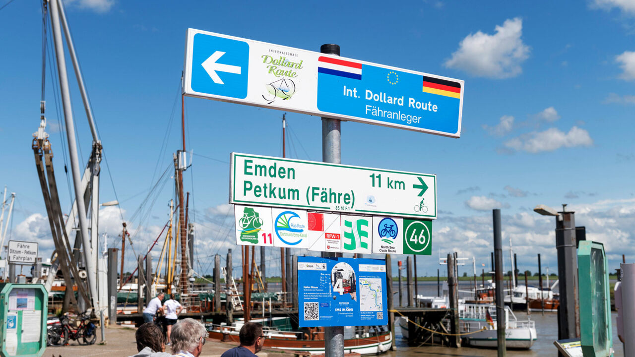 Schilder weisen am Hafen von Ditzum den Weg zur Fähre