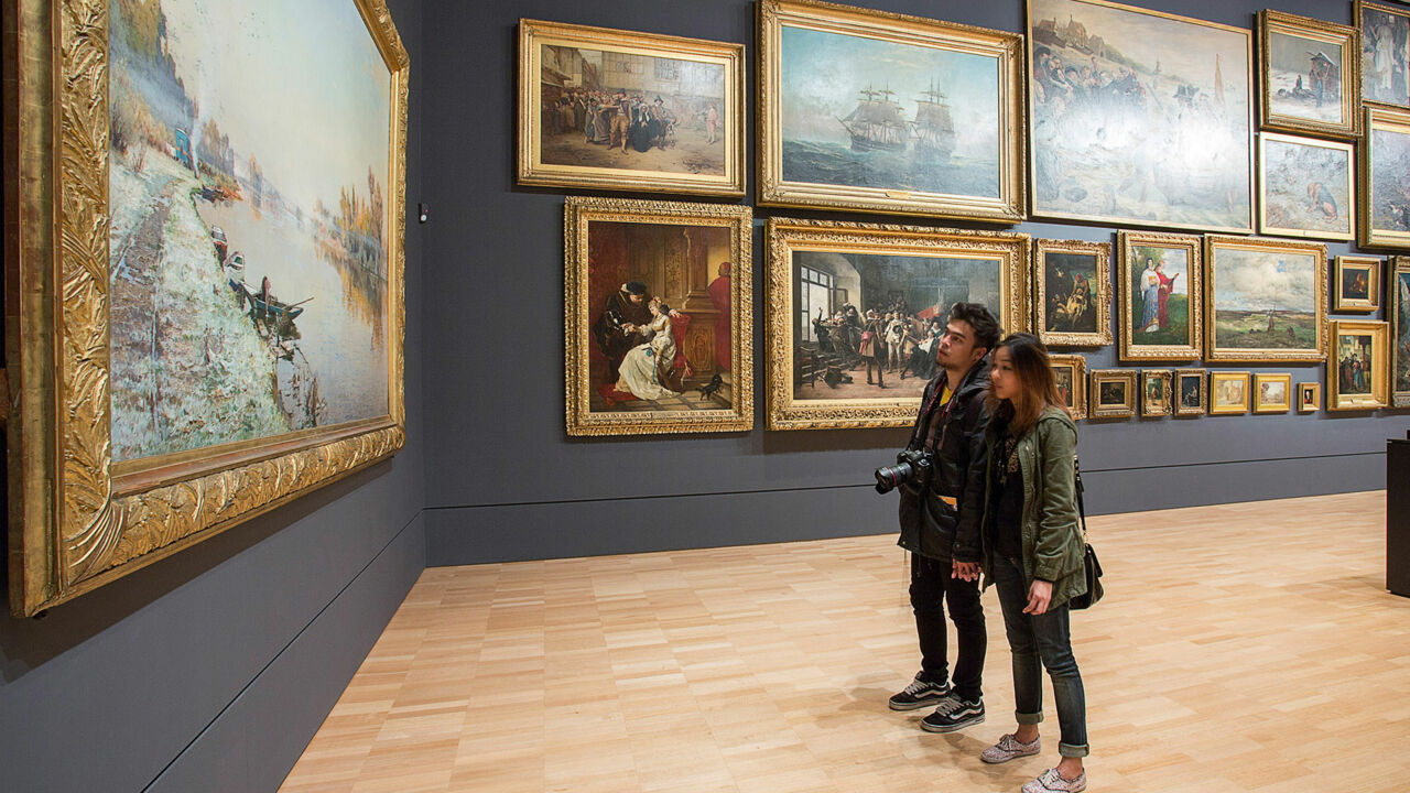 Besucherinnen stehen vor Gemälden in der National Gallery of Victoria