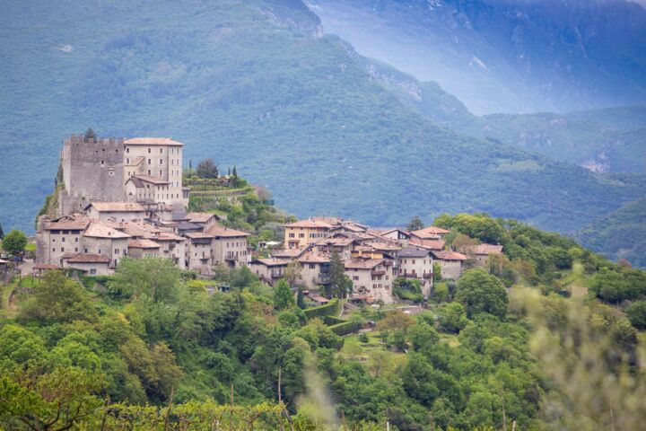 Seasons_13187688_HiRes_Blick_auf_das_Dorf_Tenno_in_der_Landschaft_des_waldreichen_Trentino_Italien