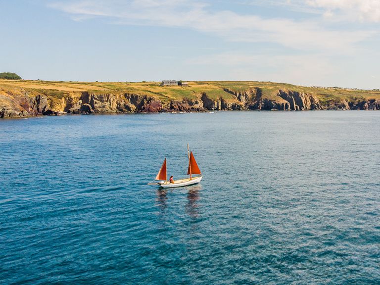 Wilde Küsten soweit das Auge reicht: Porthclais im Süden von Wales Die Küste von Porthclais mit Segelschiff, Wales