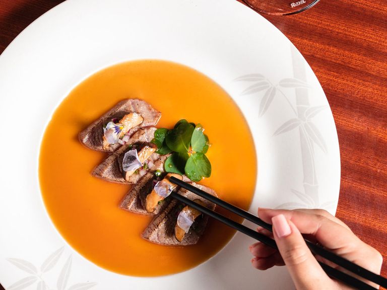 Gericht im Matsuhisa Paris, Person isst mit Stäbchen