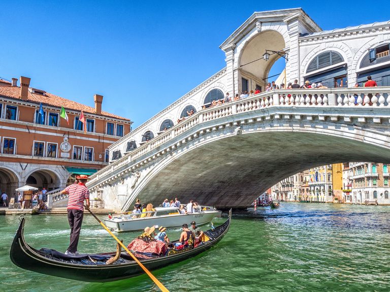 Eine Stadt wie ein Museum: die Rialtobrücke in Venedig Eine Gondel fährt durch die Rialtobrücke in Venedig
