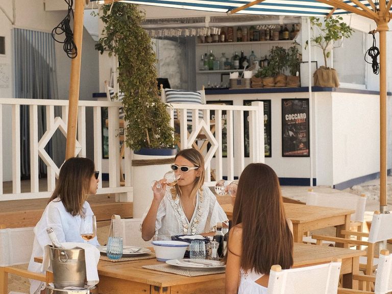 Gruppe aus drei Frauen sitzt im Coccaro Beach Club
