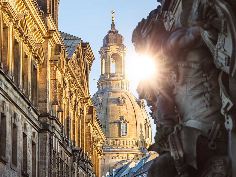 Blick zwischen historischen Gebäuden auf die Frauenkirche in Dresden