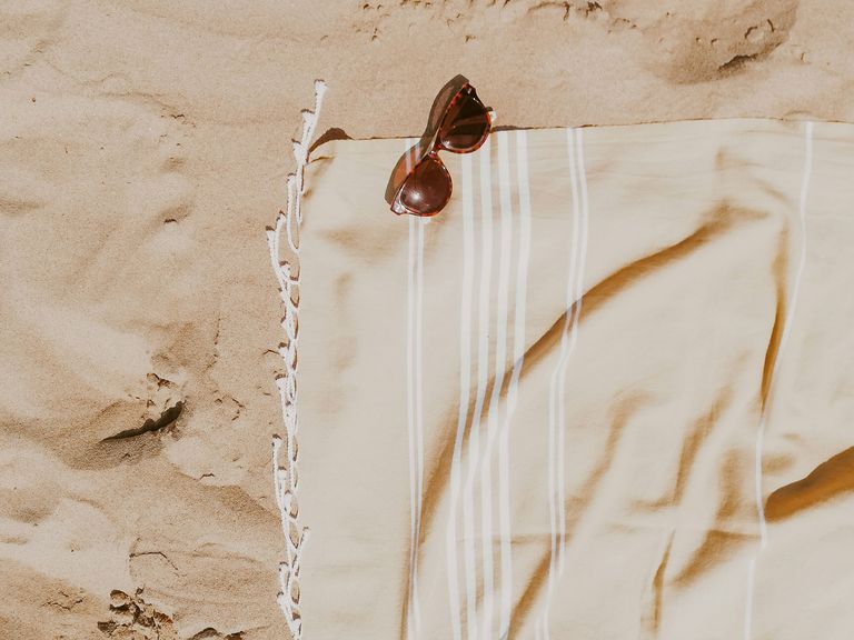 Handtuch und Sonnenbrille am Strand