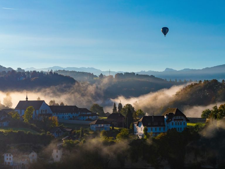 Hei&szlig;luftballon &uuml;ber Fribourg in der Schweiz