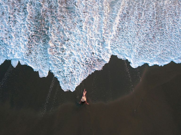 Luftaufnahme einer Frau am Lavastrand in Costa Rica