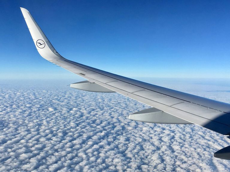 Tragfläche eines Lufthansa-Flugzeugs über den Wolken