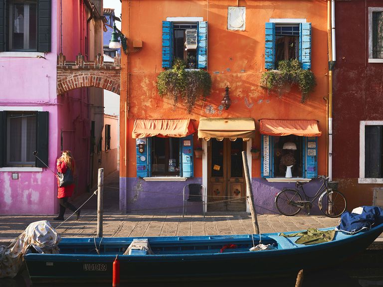 Burano liegt in der Lagune von Venedig und ist eine der schönsten Inseln Italiens. bunte Häuser von Burano sowie Fischerboot