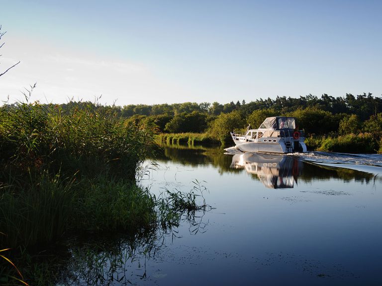 Die Peene lässt sich bestens mit dem Boot erkunden. Motorboot auf der Peene, Mecklenburg-Vorpommern