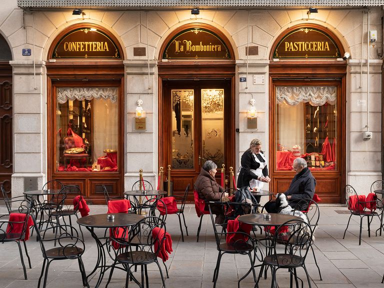 Die Pasticceria La Bomboniera in Triest vereint italienische Süßspeisen mit österreichisch-ungarischer Tradition. Menschen sitzen vor der Pasticceria La Bomboniera in Triest