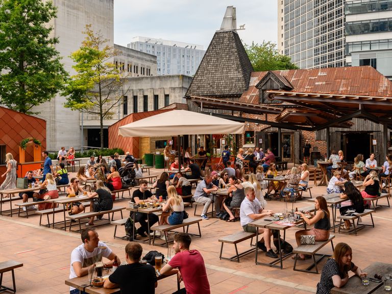 Menschen sitzen draußen im Viertel Spinningfields, Manchester