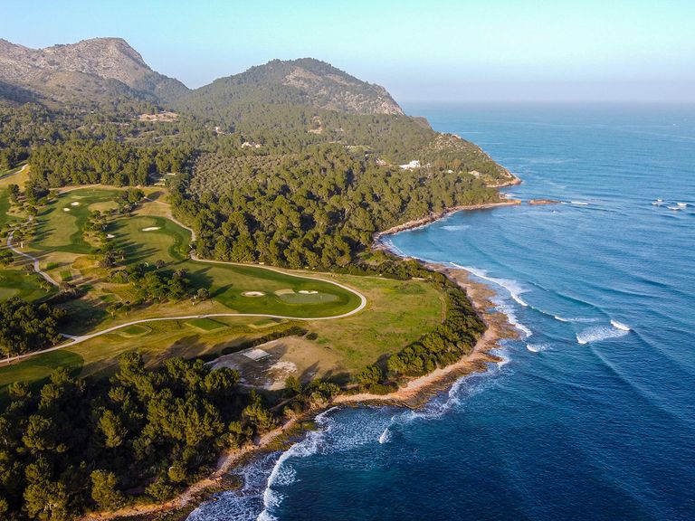 Mehr als 20 Golfplätze für Greenfeespieler:innen locken auf der größten Baleareninsel. Golfplatz an der Küste, Mallorca, Luftaufnahme