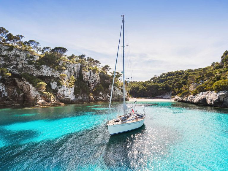 Menorca hält zahlreiche Traumbuchten bereit. Boot in einer Bucht von Menorca