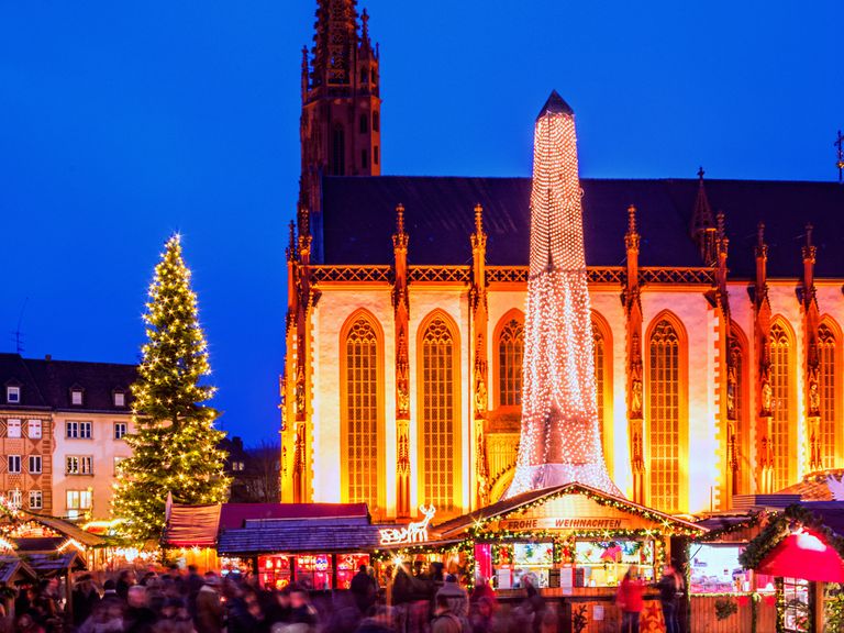 Die Marienkapelle und der Würzburger Markplatz bilden die Kulisse für den jährlichen Weihnachtsmarkt. Blick auf Marienkapelle und den Weihnachtsmarkt in Würzburg