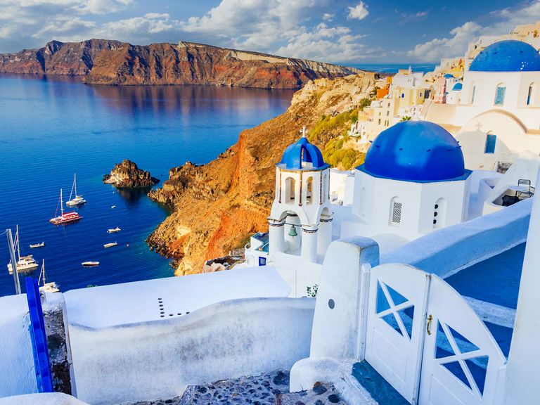 Santorini verzaubert mit weiß getünchten Häusern – und einer beeindruckenden Caldera. Oiá auf Santorini, Blick auf die Caldera und aufs Meer