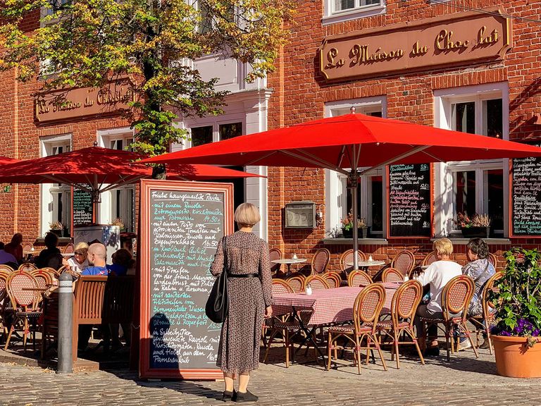 Bistro im Holländischen Viertel von Potsdam, Stühle und Sonnenschirme stehen draußen