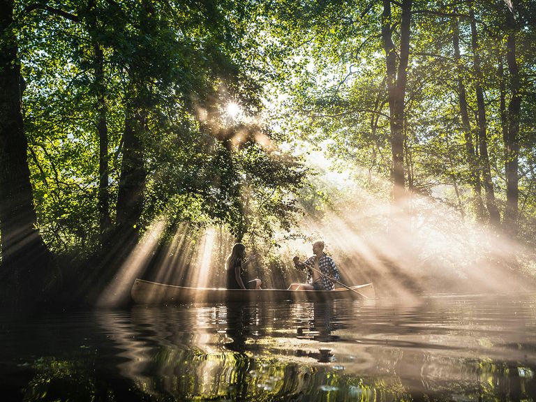 Zwei Personen paddeln in einem Boot auf einem See in Slowenien