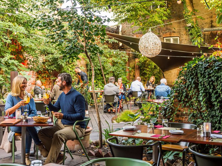 Der Garten des Miera Restaurants in Lübeck Personen sitzen im Garten des Miera Restaurants in Lübeck