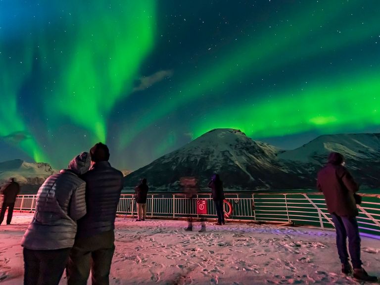 Wer mit der MS Trollfjord unterwegs ist, kann mit Glück Polarlichter bestaunen. Passagier:innen der MS Trollfjord beobachten Polarlichter in Norwegen